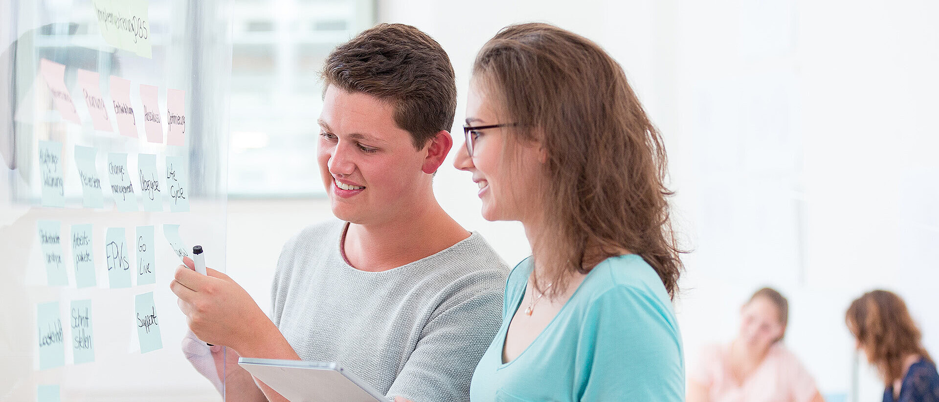 Zwei Studierende im dualen Studium Wirtschaftsinformatik besprechen ein Projekt