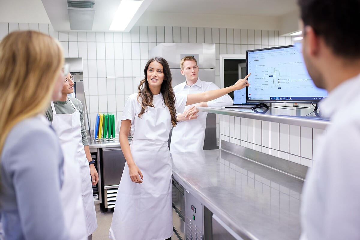 Studierende besprechen ein Projekt in der Küche