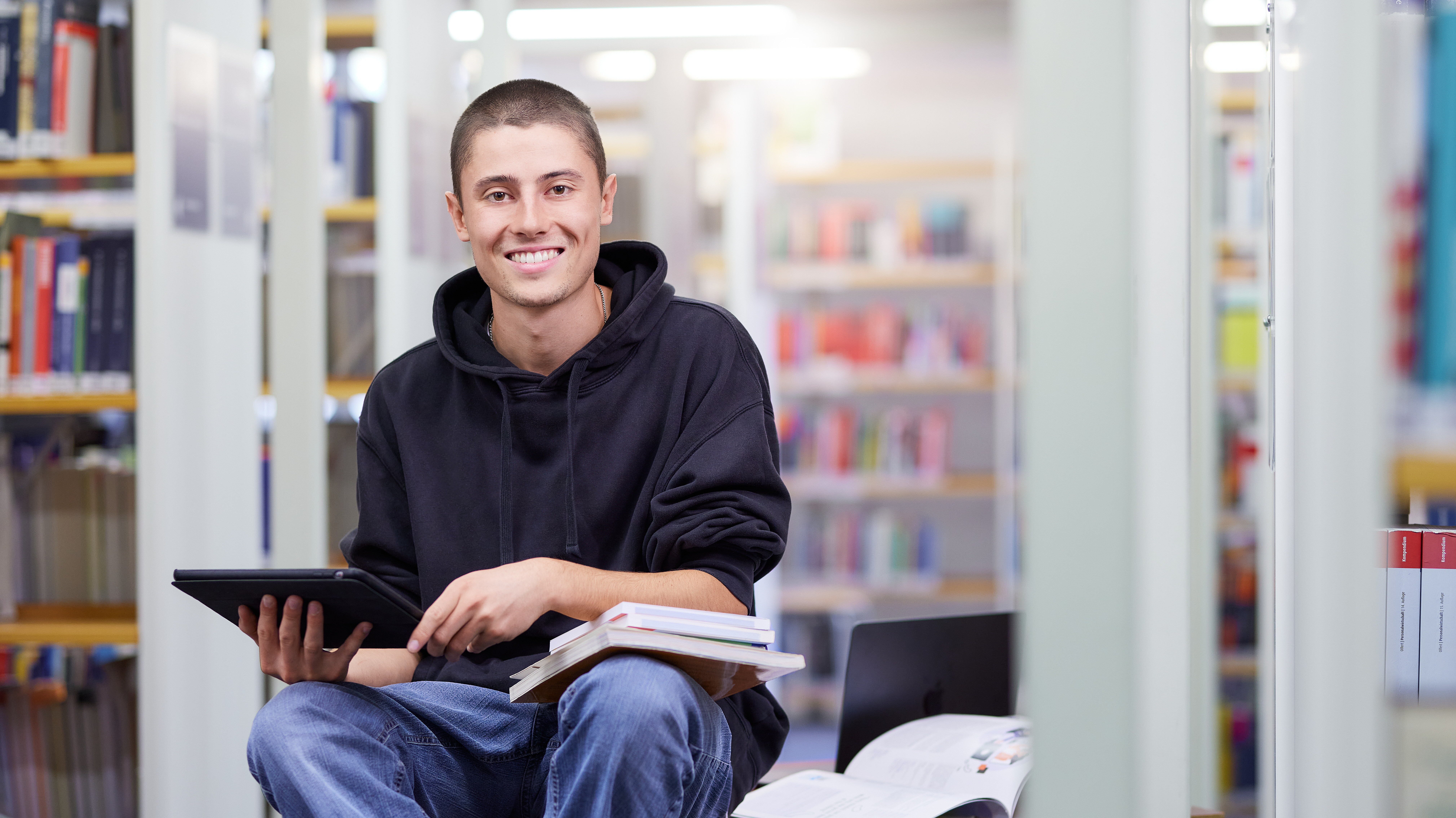 Ein Studierender im dualen Studium Wirtschaftsingenieurwesen lernt in der Bibliothek