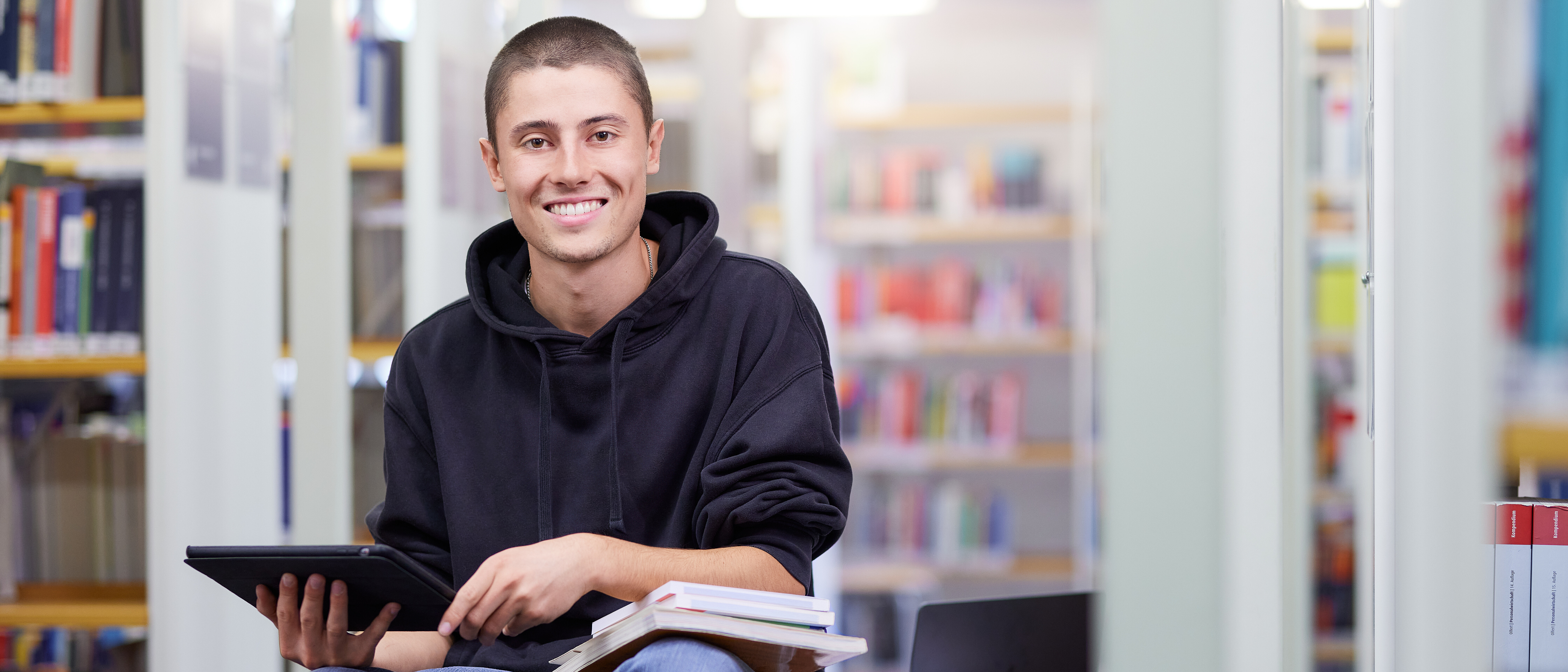 Ein Studierender im dualen Studium Wirtschaftsingenieurwesen lernt in der Bibliothek